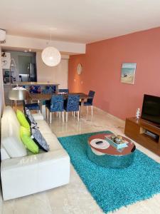 a living room with a couch and a table at Isla Bonita Tropical 107 in Palm-Eagle Beach