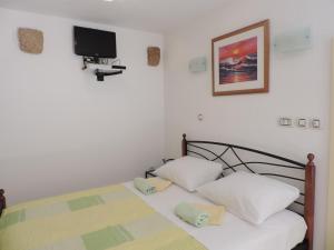 Un dormitorio con una cama con dos almohadas y un televisor. en Studio Josip, en Split