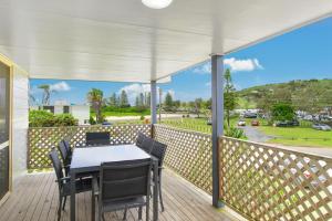 a patio with a table and chairs on a deck at Bellhaven 1, 17 Willow Street in Crescent Head