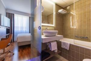 a bathroom with a sink and a mirror at Radisson Blu, Basel in Basel