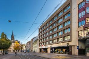 een lege straat met een gebouw op de hoek bij Radisson Blu, Basel in Bazel