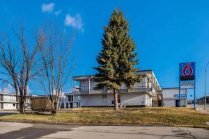 a christmas tree in front of a building at Motel 6-Fort St. John, BC in Fort Saint John