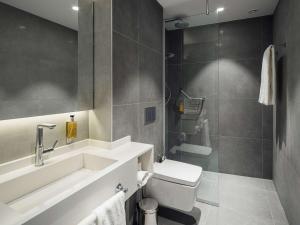 a bathroom with a sink and a toilet and a shower at Executive Residency by Best Western Amsterdam Airport in Hoofddorp