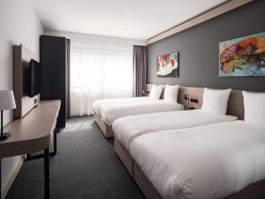 a hotel room with two beds and a television at Executive Residency by Best Western Amsterdam Airport in Hoofddorp