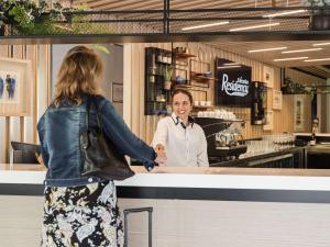 a woman is shaking the hand of a chef at Executive Residency by Best Western Amsterdam Airport in Hoofddorp