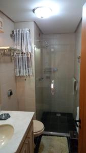 a bathroom with a shower with a toilet and a sink at Hospede-se no Coração de Gramado in Gramado