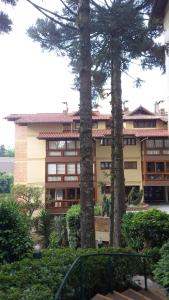a building with two palm trees in front of it at Hospede-se no Coração de Gramado in Gramado