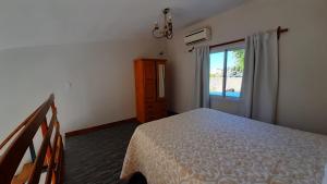 a bedroom with a bed and a sliding glass door at Navarro Departamentos Temporarios in Navarro