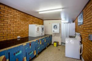 a bathroom with a washing machine and a washer and dryer at Coffs Windmill Motel in Coffs Harbour