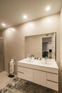 a bathroom with two sinks and a large mirror at Casa de Âncora in Vila Praia de Âncora