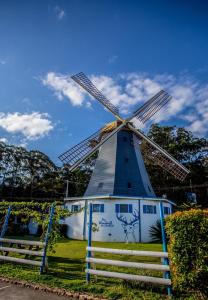 um moinho de vento azul e branco com uma cerca à volta em Coffs Windmill Motel em Coffs Harbour