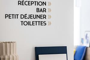 een bord op een muur dat de bar van de receptie leest en de toiletten van klanten bij Le Riviera Collection, Signature Collection by Best Western in Nice