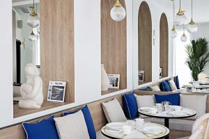 a restaurant with two tables and blue chairs at Le Riviera Collection, Signature Collection by Best Western in Nice