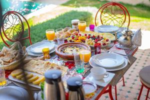 a table with food and drinks and orange juice at Domaine Alma Marrakech in Marrakesh