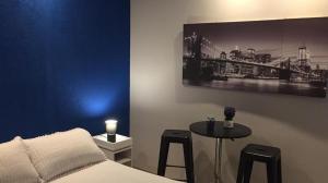 ein Schlafzimmer mit einem Bett und einem Tisch mit Hockern in der Unterkunft HOTEL COMERCIO PLAYA in Montevideo