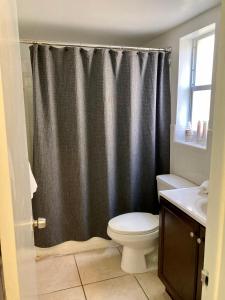 a bathroom with a shower curtain and a toilet at Beach Aqualina Apartments in Fort Lauderdale
