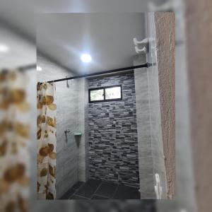a bathroom with a shower with a brick wall at Cabañas El Olimpo in Necoclí