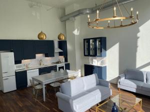 uma cozinha e sala de estar com armários azuis e uma mesa em Gold Suite by Hollyhock- Executive-Level Living em Louisville