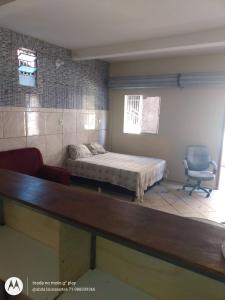 a bedroom with a bed and a chair in it at Kitnet mobiliada Madre de Deus in Madre de Deus