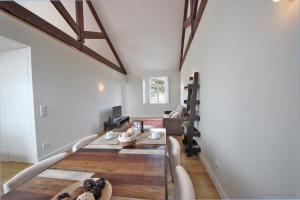 una sala de estar con paredes blancas y vigas de madera. en Oporto River and Ribeira Views, en Vila Nova de Gaia