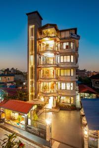 wysoki budynek apartamentowy ze sklepem przed nim w obiekcie Trekkers Inn Boutique Hotel Pokhara w mieście Pokhara