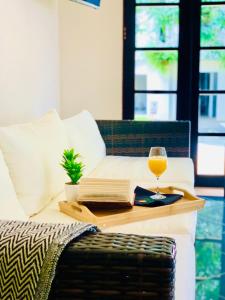 uma mesa com um copo de vinho e um livro em Hotel Mango Airport em Alajuela