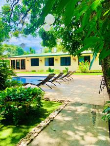 a house with a swimming pool in the yard at Hotel Mango Airport in Alajuela