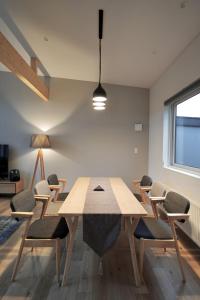 a dining room with a wooden table and chairs at Santa's House in Niseko