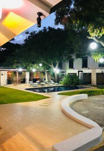 una casa con piscina di notte di Hotel Mango Airport a Alajuela