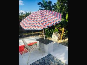 a table and two chairs with an umbrella at Room in Apartment - Bahamas petapat suite in Nassau