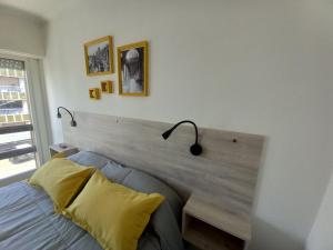 um quarto com uma cama e uma cabeceira em madeira em 2 ambientes en Playa Grande Matheu y Alem em Mar del Plata