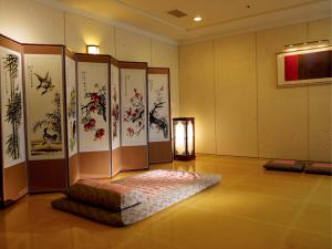 a room with paintings on the wall and a ottoman at Daegu Grand Hotel in Daegu