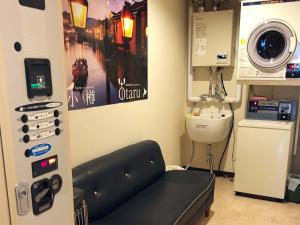 a hospital room with a washing machine and a sink at Guesthouse Otaru Wanokaze in Otaru