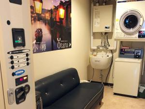 um quarto de hospital com uma máquina de lavar roupa e um lavatório em Guesthouse Otaru Wanokaze em Otaru