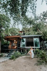 a woman sitting on a bench in front of a house at Cookies Salad Resort in Salad Beach