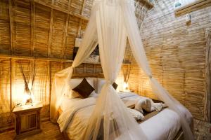 a bedroom with a bed with mosquito netting at Unicorn Bungalow in Nusa Penida