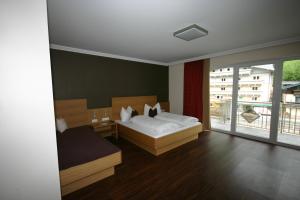 sypialnia z łóżkiem i dużym oknem w obiekcie Hotel Herzblut - Joker card included in summer w Saalbach Hinterglemm +36 zdjęć