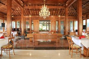 a dining room with a chandelier and tables and chairs at Djembar Inn in Kalasan