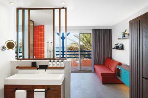 bagno con lavandino e divano rosso di SALT of Palmar, an adult-only boutique Hotel a Belle Mare