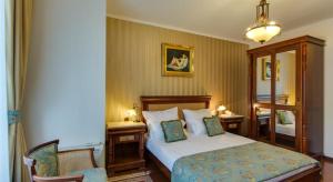 Habitación de hotel con cama y espejo en Vila Paris Boutique Hotel, en Bucarest