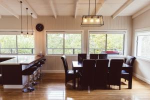 a dining room with a table and chairs and windows at WildLife Lodge Katoomba in Katoomba