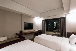a hotel room with two beds and a television at Seoul Garden Hotel in Seoul