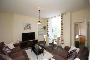 a living room with a couch and a table at 2 bed flat, Cambuslang, Glasgow, free parking in Cambuslang