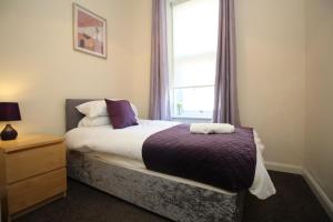 a bedroom with a bed and a window at 2 bed flat, Cambuslang, Glasgow, free parking in Cambuslang