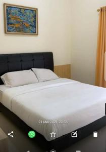 a bed in a room with avertisement for at Vila Bandungan in Bandungan