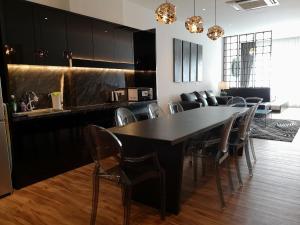 Palm Suite Ipoh Octagon في ايبوه: غرفة طعام مع طاولة سوداء وكراسي