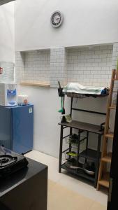a kitchen with a shelf and a clock on the wall at Vila Bandungan in Bandungan