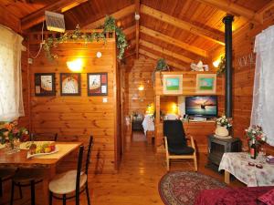 a log cabin with a dining room and a tv at הבקתה הגלילית in Arbel