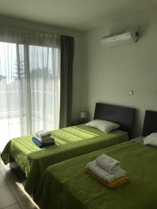 ペイヤにあるCoral Bay Villa 4, walking distance to Coral Bayのベッドルーム1室(ベッド2台、緑のシーツ、窓付)