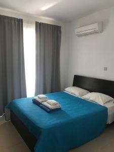 - une chambre avec un lit bleu et des serviettes dans l'établissement Coral Bay Villa 4, walking distance to Coral Bay, à Peyia